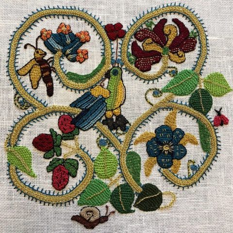 17th century garden embroidery sample with vines, plants, and animals