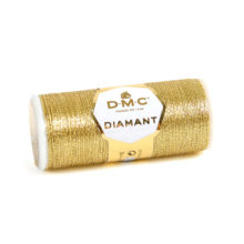 A spool of DMC Diamant Light Gold on a white background