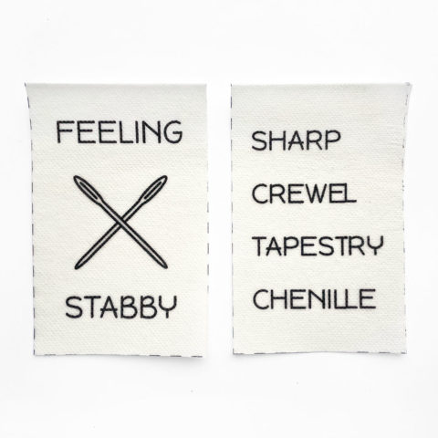 two pieces of printable stabilizer. The left one shows a picture two crossed needles and the words "feeling stabby." The right one shows a stack of words for needle types: sharp, crewel, tapestry, and chenille.