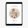 mushrooms, flowers, and acorns embroidered on natural linen displayed in a tablet