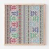 A Palestinian needlework of geometric shapes stitched in repeating columns between messages of holiday greetings