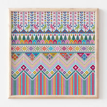 A colorful modern repeating Palestinian tatreez cross-stitch pattern in a blond wood frame depicting rows of striped mountaind, houses, trees, birds, and flowers