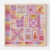 Palestinian modern tatreez cross-stitch sampler in warm colors in a blond wood frame