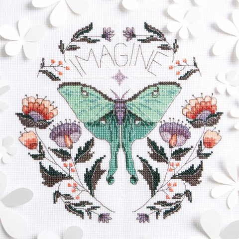 a cross-stitch of a fancy green moth and flowers with the word "imagine" above