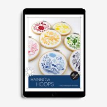 A tablet showing the patterns for seven folk art embroideries each using a single color of the rainbow