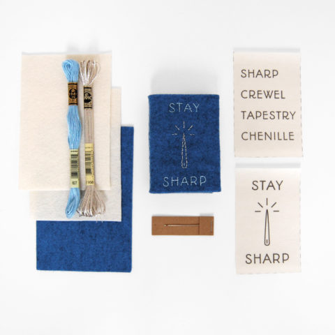 Stay Sharp embroidered felt needle book surrounded by the supplies needed to make the project