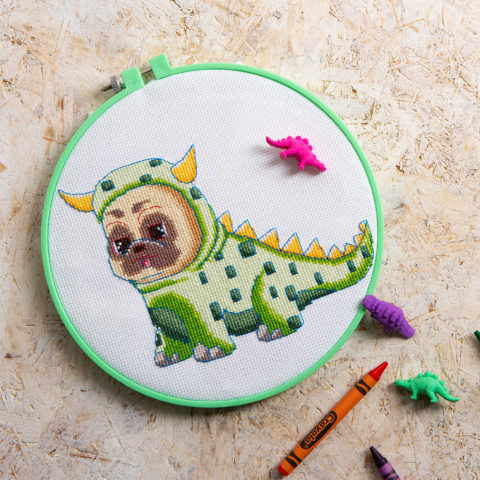 Cute cross-stitch of a pug dog in a dinosaur costume