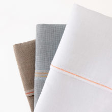 Brown, grey, and white folded linen fabric arranged in a fan