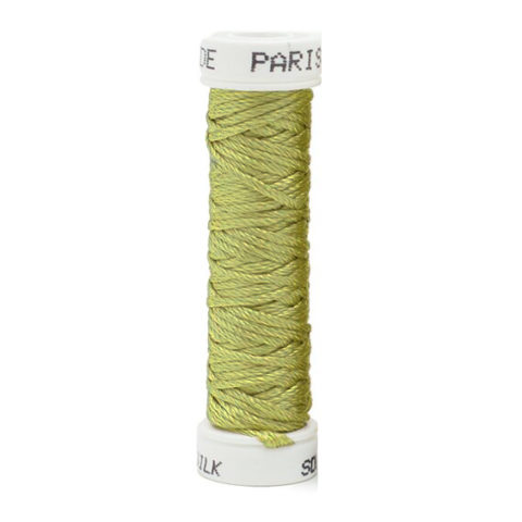 a spool of green silk thread on a white background