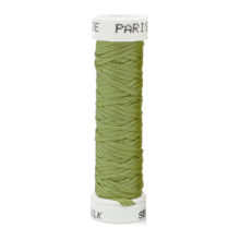 a spool of green silk thread on a white background
