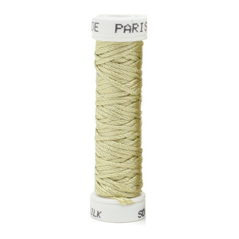 a spool of pale green silk thread on a white background