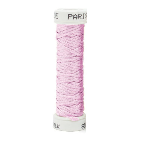 a spool of light pink purple silk thread on a white background