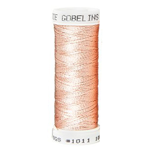 a spool of light peach silk thread on a white background
