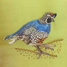 A needle painted blue and brown quail embroidered on a square of olive green silk