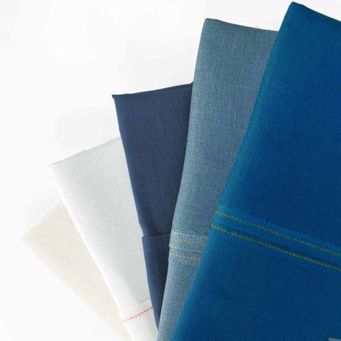 five pieces of linen fabric in various blues and whites arranged in a fan