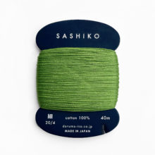 Spring green sashiko thread on a navy blue cardboard bobbin