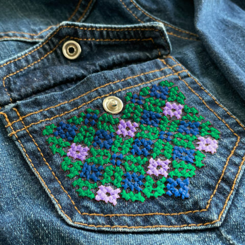 diamond lattice tatreez pattern stitched onto the pocket of a denim shirt