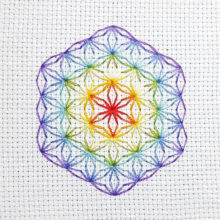 flower of life mystical circle design stitched using blackwork embroidery in rainbow colors on white aida canvas