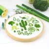 Several folk art objects embroidered in green in a wooden hoop
