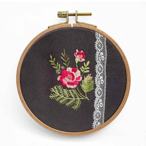 embroidery of a spray of roses on gray fabric