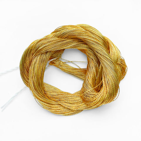 a twisted skein of gold embroidery thread on a white background