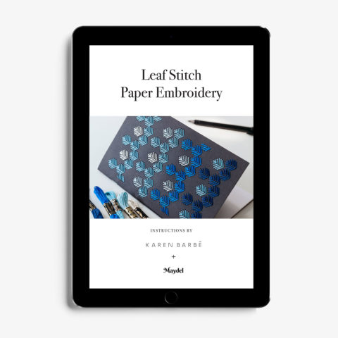 A tablet showing the cover page of instructions for a leaf stitch embroidery pattern done in blue on a black notebook