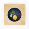 embroidery of a lemon branch inside a square blond wood hoop