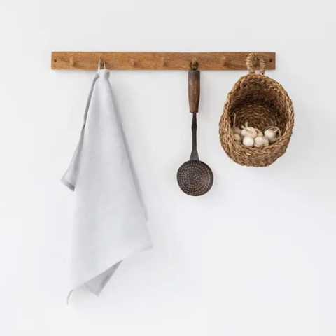light gray tea towel hangin on a wooden wall peg