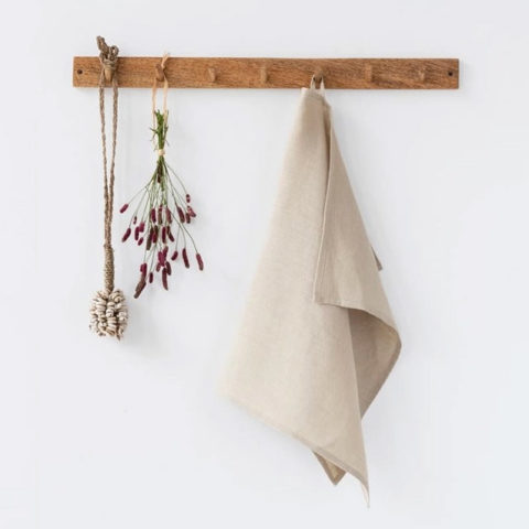 natural linen tea towel hangin on a wooden wall peg