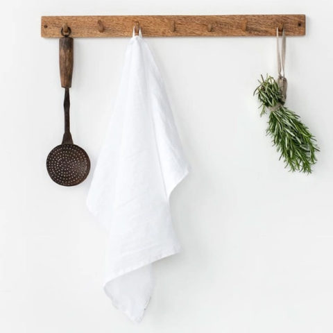 white tea towel hangin on a wooden wall peg