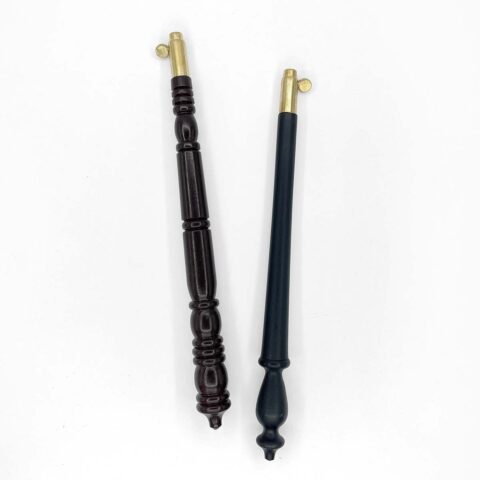 two carved wood tambour handles in dark brown and black with brass caps on a white background