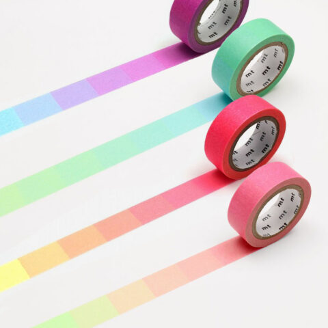four rolls of washi tape unspooled to show various printed color gradients
