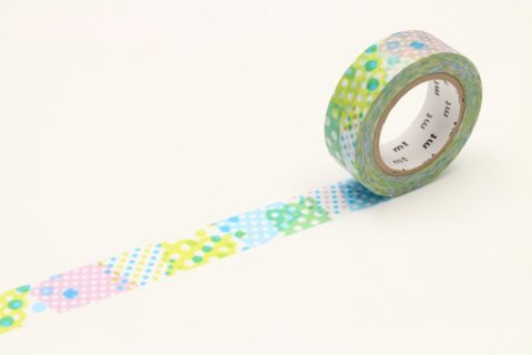 a roll of washi tape unwound to show colorful dot patterns in cool tones