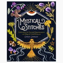 A black book cover with the title "Mystical Stitches" in white, surrounded by embroidered symbols of the natural world in purple, green, and gold