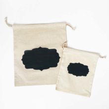 a small and a large natural cotton drawstring bag with a black frame printed in the center of each laid flat on a white background