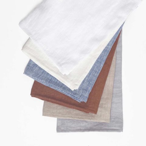 a stack of six linen tea towels in neutral colors