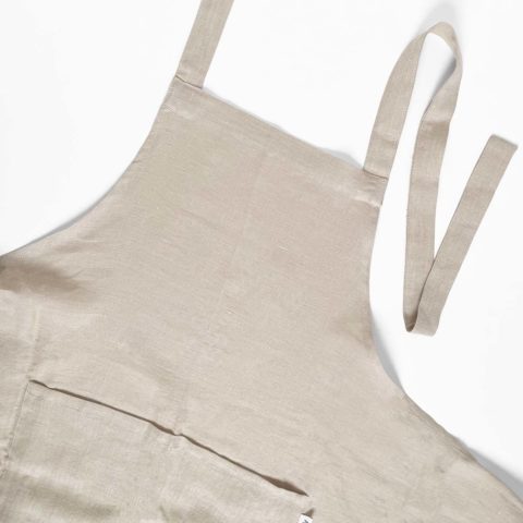 close up of the bib of a natural linen apron, untied and laid flat