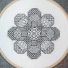 A blackwork embroidery of a flower shape made out of eight octagons filled with various stitch patterns