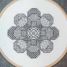 A blackwork embroidery of a flower shape made out of eight octagons filled with various stitch patterns