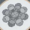 A blackwork embroidery of a flower shape made out of eight octagons filled with various stitch patterns