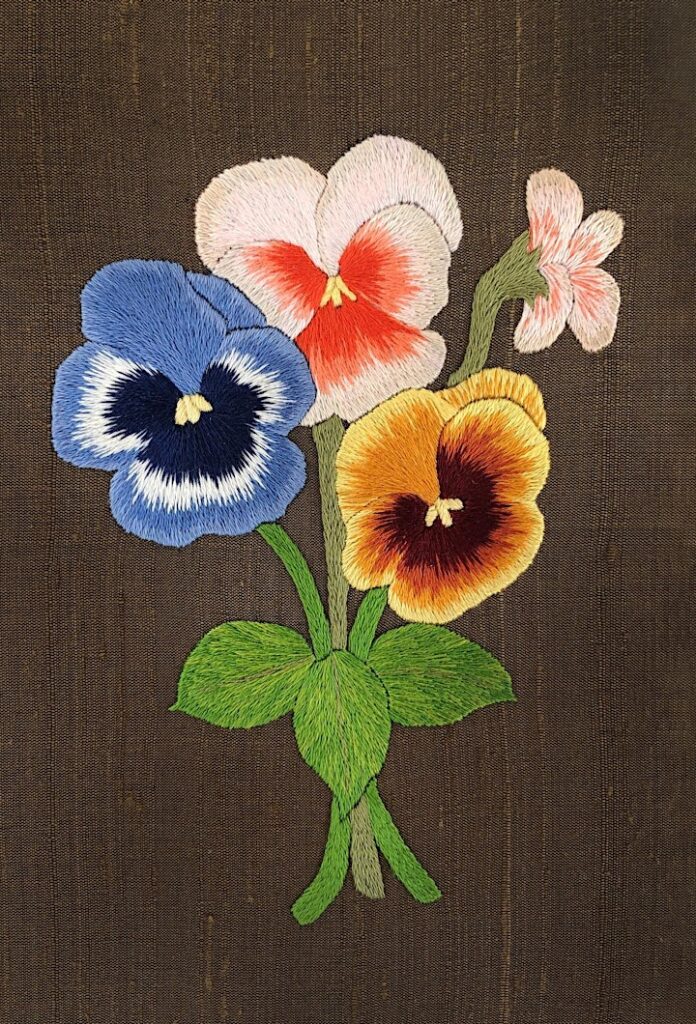 realistic embroidery of a pansy spray on gold silk
