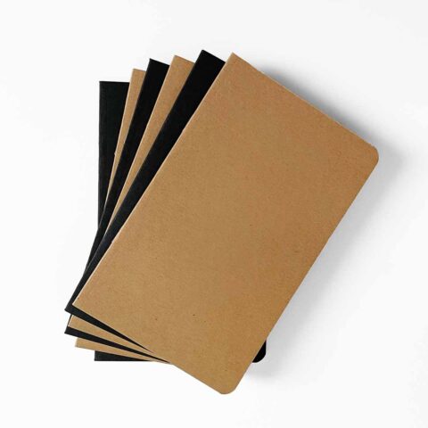 A slightly fanned out stack of blank notebooks with black and kraft brown covers