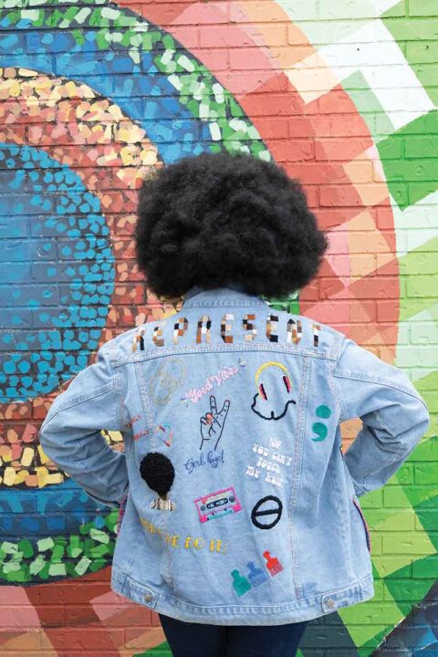 The back of a denim jacket embroidered with various small motifs