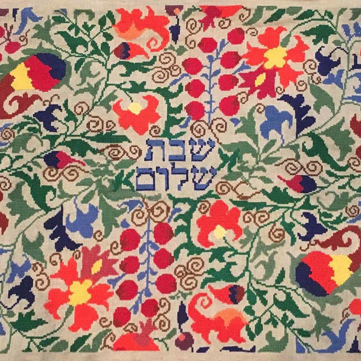 colorful botanical folk art pattersn cross-stitched around the hebrew words shabbat shalom