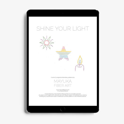 A Tablet showing the cover page for mini light-themed paper embroidery patterns including a sun, a star, and a candle