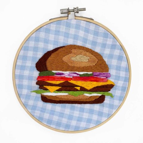 A realistic hamburger embroidered blue gingham fabric