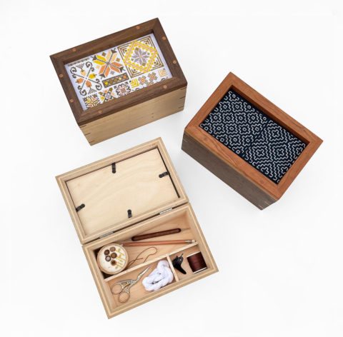 three wooden needlework keepsake boxes with frame lids, one of which is propped open to revealed divided interior compartments