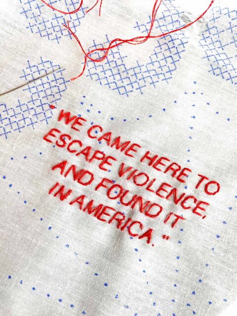 a quotation from a gun violence survivor embroidered in red on a white and blue piece of fabric