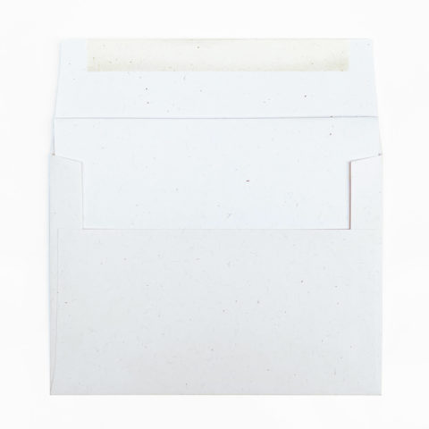 a white recycled a7 folded blank notecard peeking out of a matching envelope