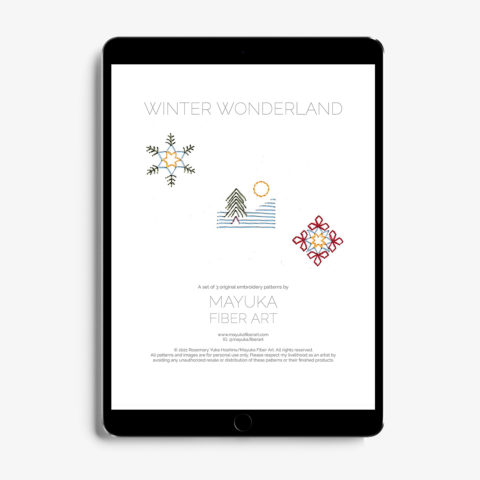 A Tablet showing the cover page for mini winter-themed paper embroidery patterns including two snowflakes and a tree on a snowy mountain